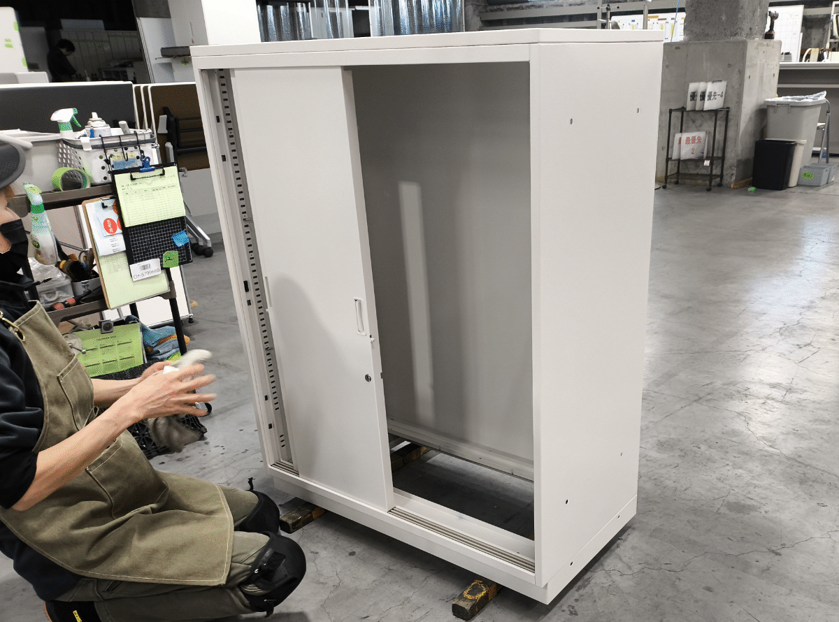 中古書庫の棚板を一枚ずつ清掃する様子