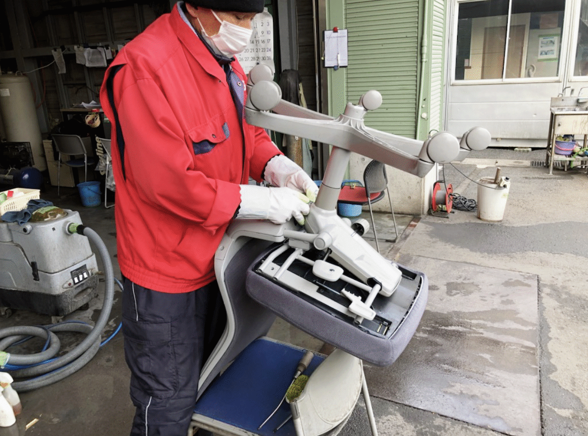 中古オフィスチェアの座面をスチーム洗浄する様子