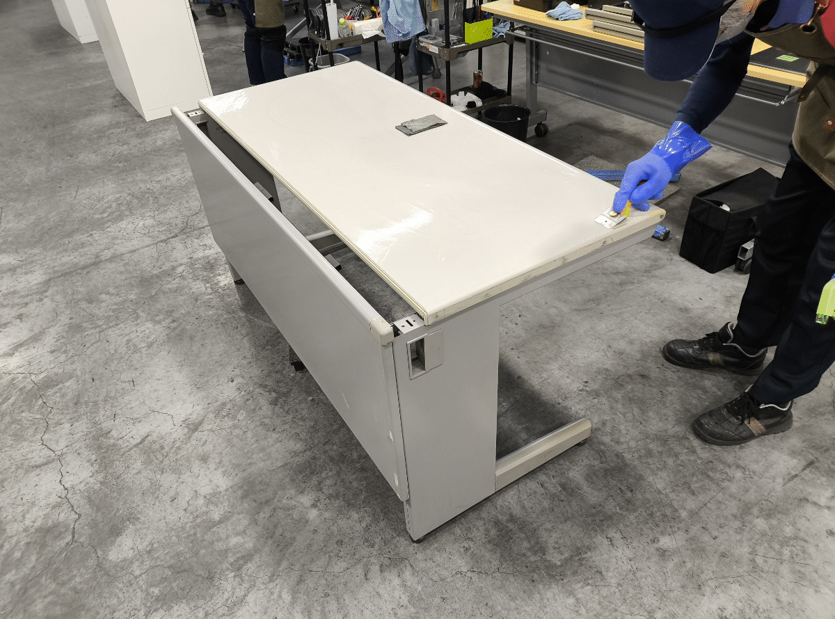 中古デスクの引き出し内部を丁寧に清掃する様子